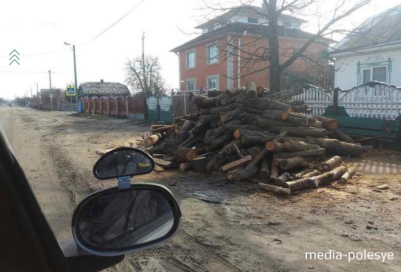 Тротуары покрыты землёй, на них складированы дрова