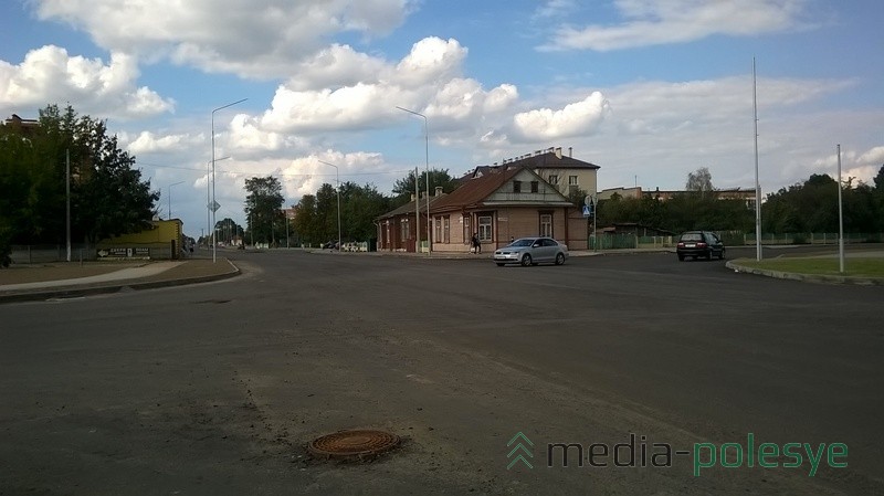 Уложен только первый слой асфальта, так что пока торчат крышки люков и решётки ливнёвок