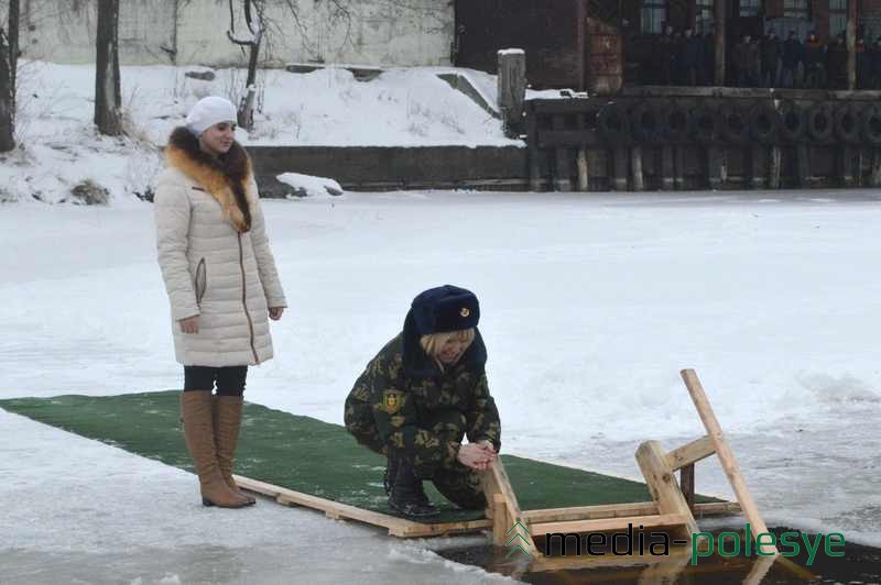 Те, кто не решились окунуться в купель, омыли лицо крещенской водой. На заднем фоне рабочие судоремнотного завода наблюдают за омовением