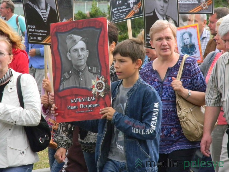 Возможно, парень несёт портрет прадеда