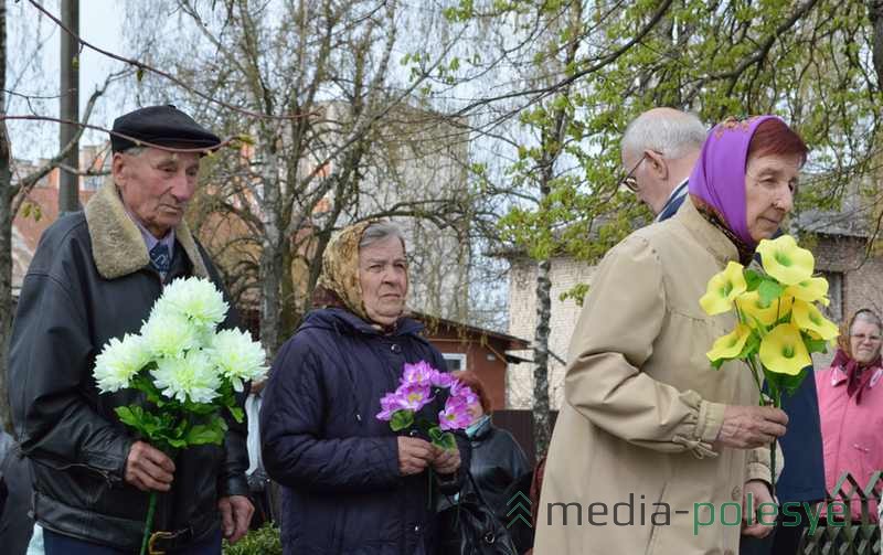 Члены организации малолетних узников фашизма несут цветы к монументу