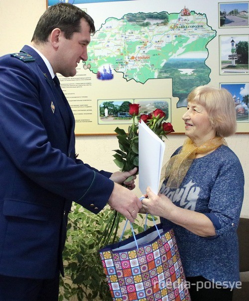 Цветы и подарок Светлане Кирилловне Джуро вручает прокурор Столинского района Дмитрий Позняк