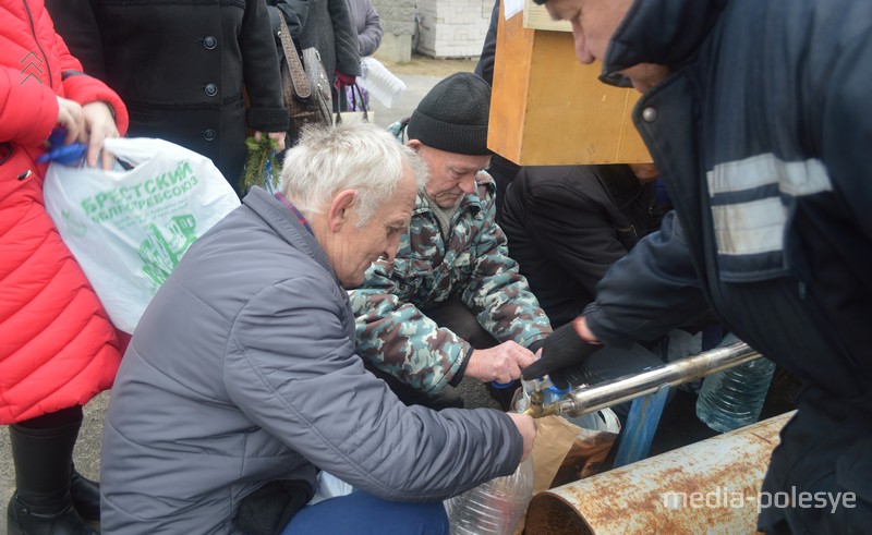  Люди набирают освящённую воду