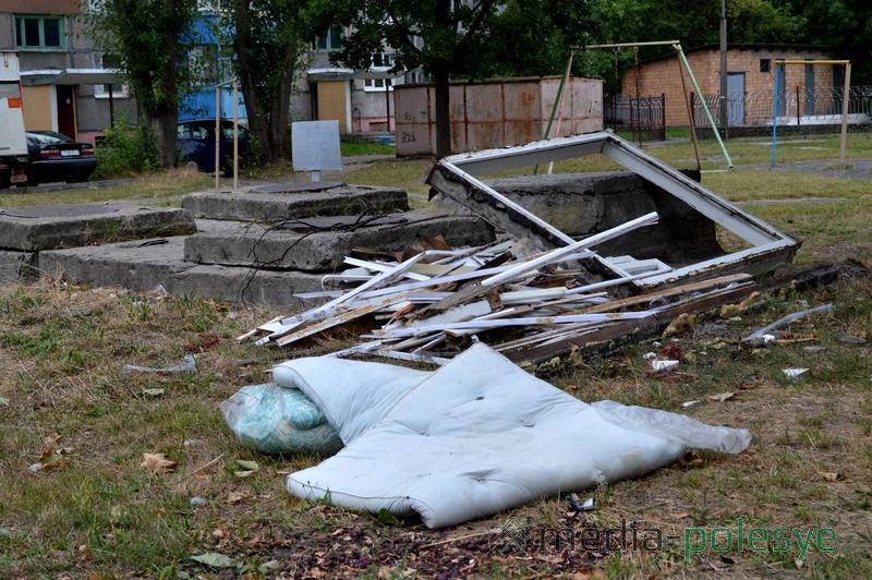 Прямо посреди двора оставлены видавшие виды матрацы и демонтированное деревянное окно, что создаёт депрессивный пейзаж