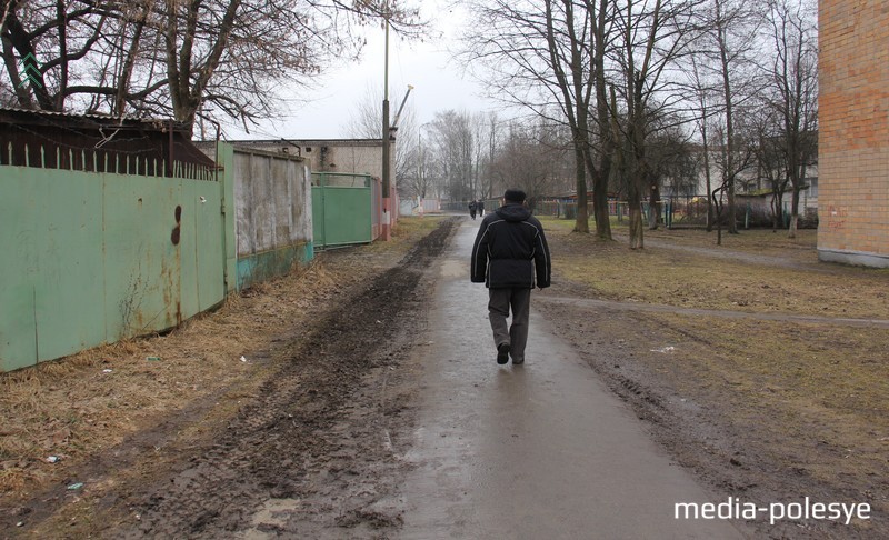 Подъезда к контейнеру нет, и тяжёлый МАЗ-мусоровоз едет по тротуарной дорожке, прокладывая длинную колею