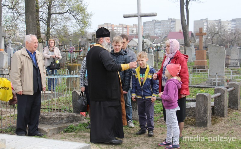 Священники поздравляют всех с Воскресением Христовым и идут освящать могилы