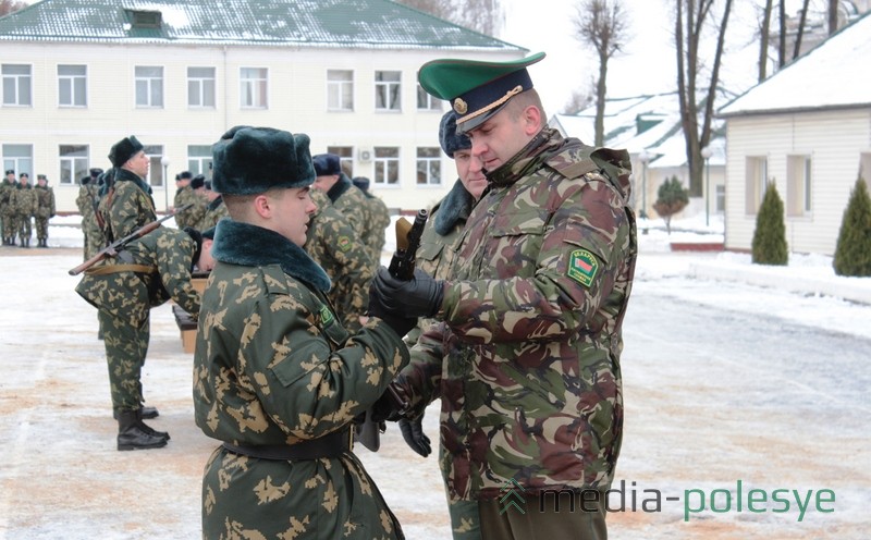 Командир пинских пограничников Максим Бутранец (справа) вручает оружие молодому пограничнику