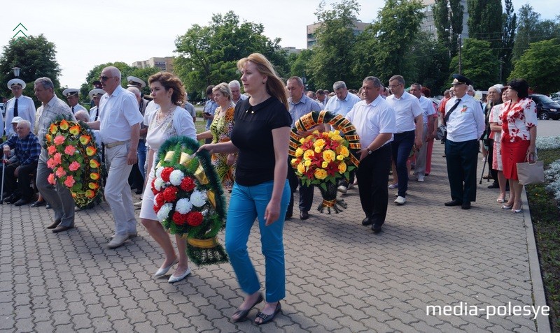 Представители предприятий и городских властей несут венки к памятнику