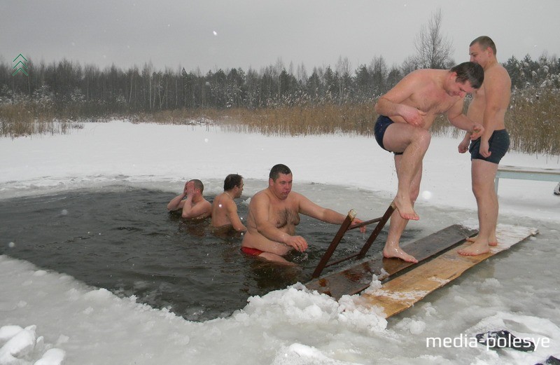 Сергей Невдах (на выходе из проруби) окунается одним из первых. Мостик он смастерил с соседями. Фото из архива, 2015 год