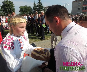 Бережно берёт каравай хлебороб