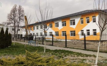 На белом фасаде оранжевое солнце