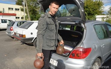 Игорь Киценко достаёт из багажника машины 36-килограммовые гири, которые всегда при нём