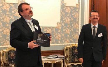 Александру Ильину вручают премию за лучшую научную публикацию