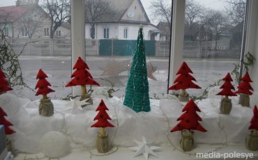 Красные ёлки на белоснежном подоконнике магазина