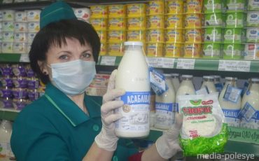 Продавец 5 разряда Ирина Харитонович демонстрирует молоко «Асаблiвае» и последнюю новинку завода – творог «Столовый»