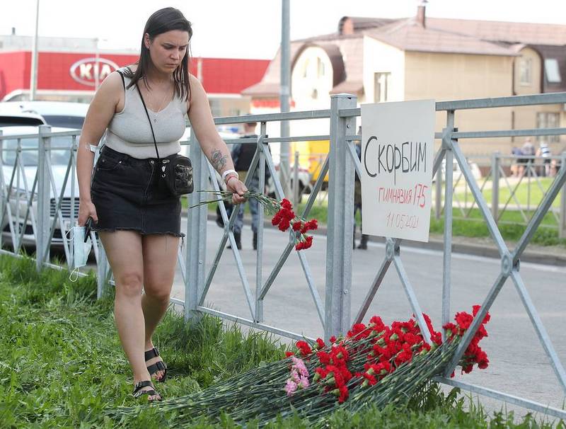 Местная жительница возлагает цветы у школы № 175, где появился стихийный мемориал / Фото: © Егор Алеев/ТАСС