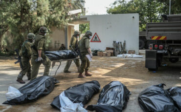 Военные выносят тела израильских жителей из разрушенного дома, 10 октября 2023 года, Кфар-Аза. Фото: Ilia Yefimovich / picture alliance via Getty Images