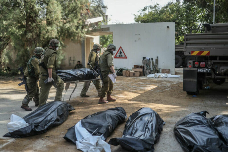 Военные выносят тела израильских жителей из разрушенного дома, 10 октября 2023 года, Кфар-Аза. Фото: Ilia Yefimovich / picture alliance via Getty Images