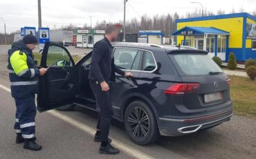 Сотрудник ГАИ и водитель в пункте контроля и оплаты «Редьки» на границе с РФ. Фото: «Минск-Новости»