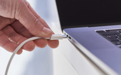 Laptop charger in hands close up. Discharged low battery at comp
